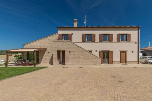 a large white house with a brick driveway at Italian Experience-Villa Clair in Fermo