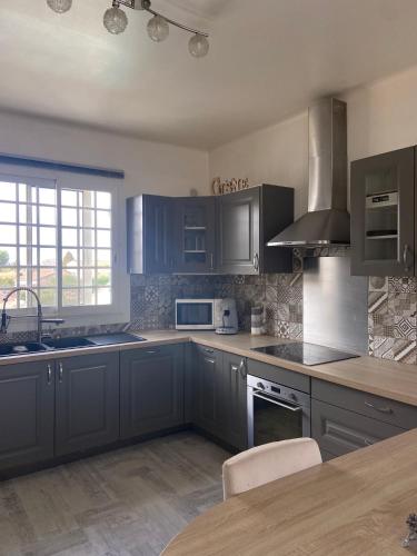 une cuisine avec des armoires bleues et un comptoir dans l'établissement La provençale, à Fontvieille