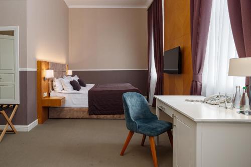 a bedroom with a bed and a desk with a chair at Modern Art Hotel in Lviv