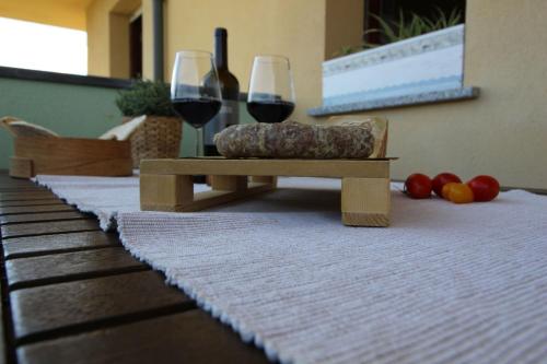a table with two glasses of red wine and fruit at Italian Experience-Bellaria Suite Apartment in Bellaria-Igea Marina