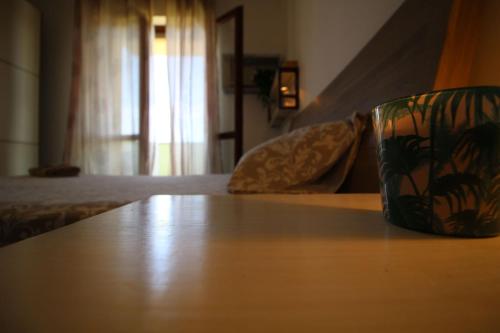a coffee cup sitting on a table in a bedroom at Italian Experience-Bellaria Suite Apartment in Bellaria-Igea Marina