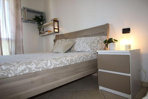 a bedroom with a bed with a wooden headboard at Italian Experience-Bellaria Suite Apartment in Bellaria-Igea Marina