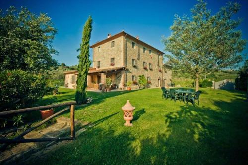 a house with a fire hydrant in front of a yard at Italian Experience-Il Fienile Holiday Home in Lamporecchio