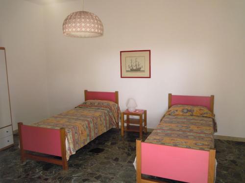 Pokój z 2 łóżkami, stołem i lampką w obiekcie Italian Experience-Casa Argentario w mieście Giannella
