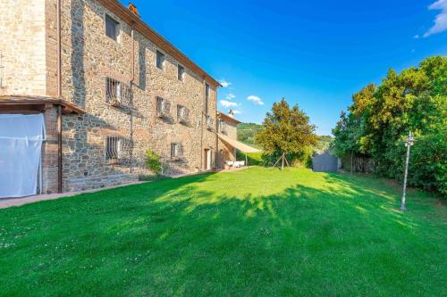 a large yard in front of a brick building at Italian Experience-Il Fienile Holiday Home in Lamporecchio
