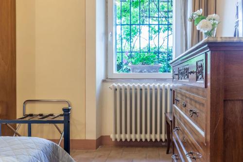 a bedroom with a dresser and a window and a radiator at Italian Experience-Il Fienile Holiday Home in Lamporecchio