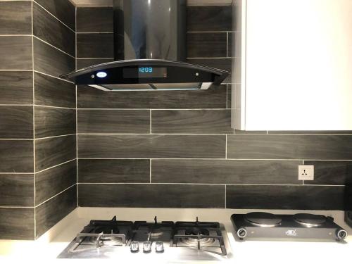 a stove top oven in a kitchen with a hood at BNR - The Opus Residences - Studio Luxury Apartment Gulberg in Lahore