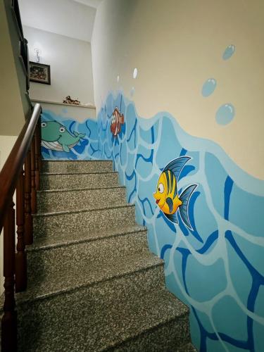 a stairwell with a mural of the ocean at Fish Luck Guesthouse in Xiaoliuqiu