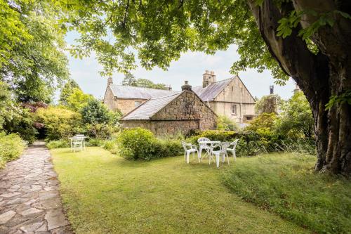 a garden with tables and chairs in front of a building at Host & Stay - Summerhill Court Lodges in Alnwick