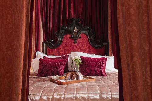 a bed with a red headboard and a tray with flowers on it at Lumley Castle Hotel in Chester-le-Street