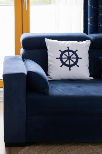 a blue couch with a pillow with a steering wheel on it at Modern Apartments with Parking and AC Warsaw Suburbs by Noclegi Renters in Konstancin-Jeziorna