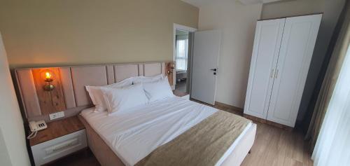 a bedroom with a large white bed in a room at Petra Port Hotel in Tuzla