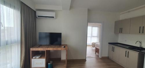 a kitchen with a table with a television on it at Petra Port Hotel in Tuzla