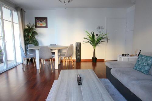 un salon avec un canapé, une table et des chaises dans l'établissement TRIANONS5 6 ppl apartment - 15min walk Disneyland, à Serris