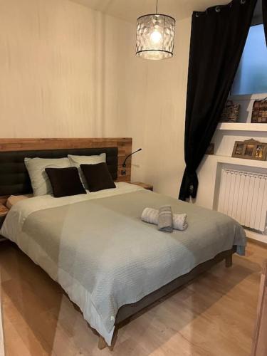 une chambre avec un grand lit avec des oreillers dessus dans l'établissement Appartement cosy au Centre, à Montignac