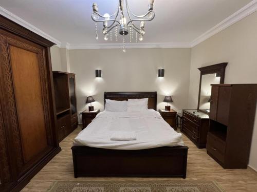 une chambre avec un lit et un lustre dans l'établissement Luxurious apartment in private compound, in new cairo, au Caire