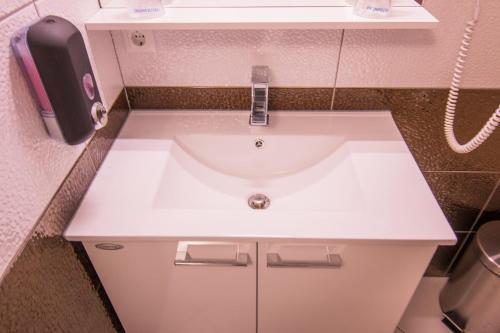 a white sink in a bathroom with a phone at Vila Lemic Postojna in Postojna