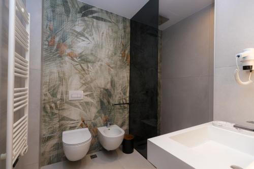 a bathroom with a toilet and a sink and a tub at Diora'S Hotel and Apartments in Vlorë