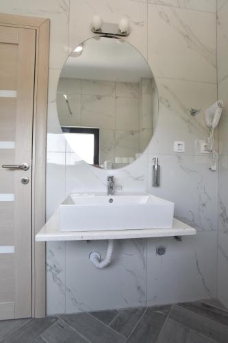 a white bathroom with a sink and a mirror at Apartments A Čanj in Čanj