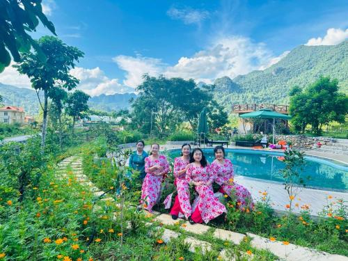 a group of women in pink robes sitting next to a pool at Pác Bó Boutique Hotel in Cao Bằng