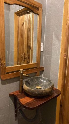 a bathroom with a stone sink and a mirror at Pác Bó Boutique Hotel in Cao Bằng