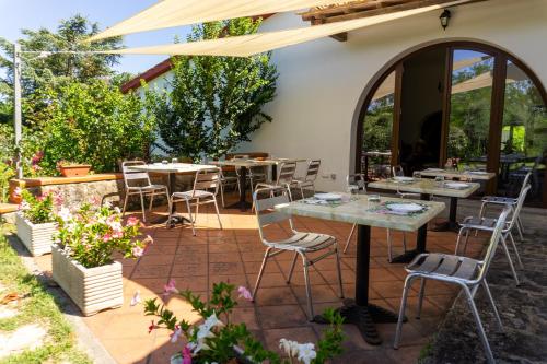 un patio con tavoli e sedie in giardino di Villa Nerone B&B a Lorenzana