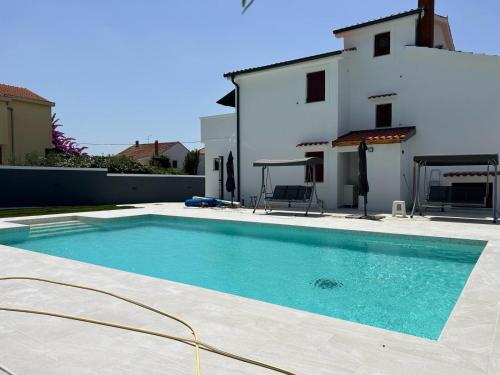 a swimming pool in front of a house at Villa Sonja in Biograd na Moru