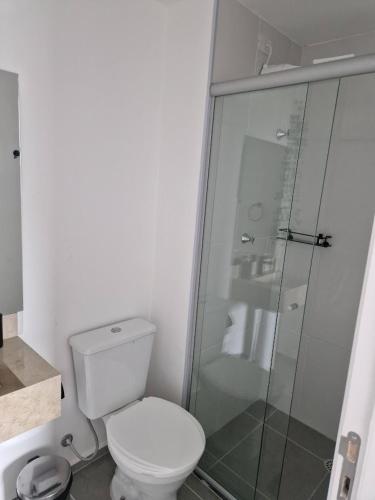 a bathroom with a toilet and a glass shower at Studio Liberdade in São Paulo
