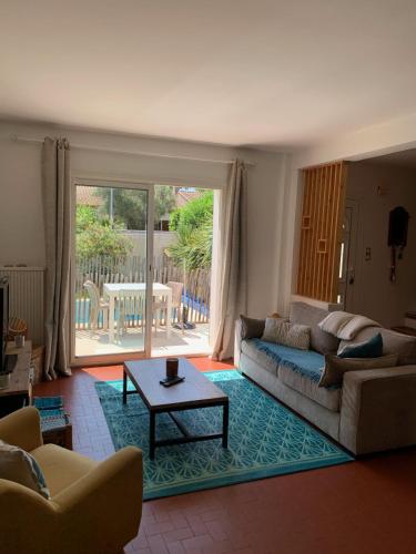 un salon avec un canapé et une table dans l'établissement Villa avec piscine proche de la mer, à Lattes