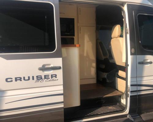 an open door of a white van with the door open at Private and cozy RV with full hookups in a convenient area with direct bus to NYC Manhattan only 2 blocks away in Linden