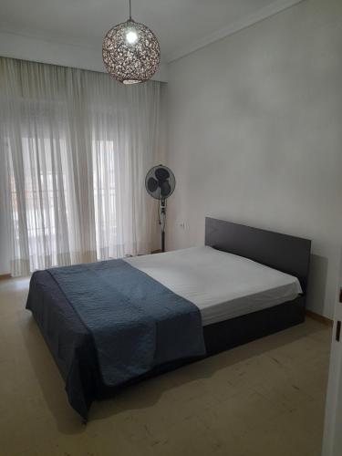 ein Schlafzimmer mit einem großen Bett und einem Ventilator in der Unterkunft Elegant Home in Nea Iraklitsa