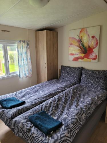 una camera da letto con un letto con cuscini blu di Chalet bij Lente van Drenthe nabij meer a Gasselte