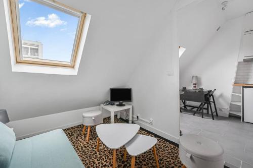 un salon blanc avec une fenêtre et un bureau dans l'établissement Le Perchoir du 16e - Wifi - Studio 2 Prs, à Paris