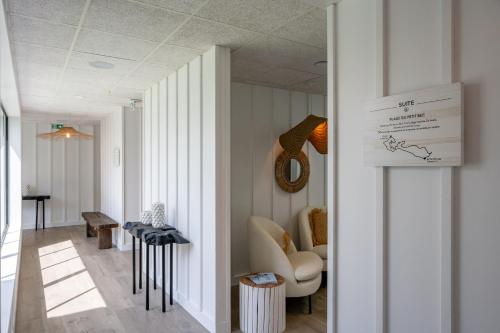 a hallway with a room with a chair and a table at Hôtel Atalante - Relais Thalasso & Spa in Sainte-Marie-de-Ré