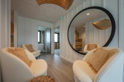 a living room with two chairs and a mirror at Hôtel Atalante - Relais Thalasso & Spa in Sainte-Marie-de-Ré