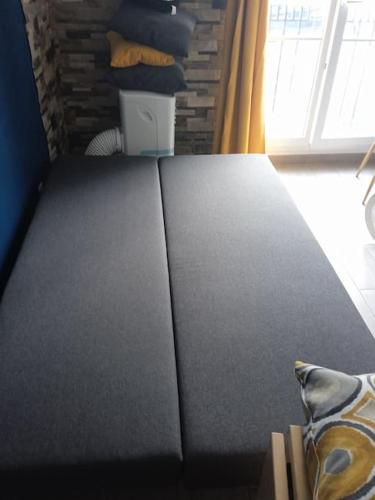 - un canapé noir avec un oreiller dans l'établissement DISNEYLAND PARIS DINA 2 rooms, à Serris