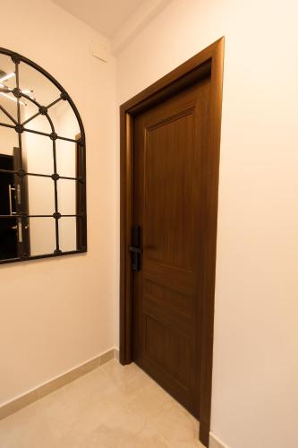 a wooden door in a room with a mirror at Al Centro in Bucharest