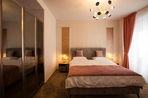 a bedroom with two beds and a chandelier at Al Centro in Bucharest