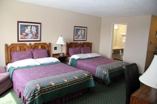 a hotel room with two beds with purple sheets at Diamond Motor Inn in Owen Sound