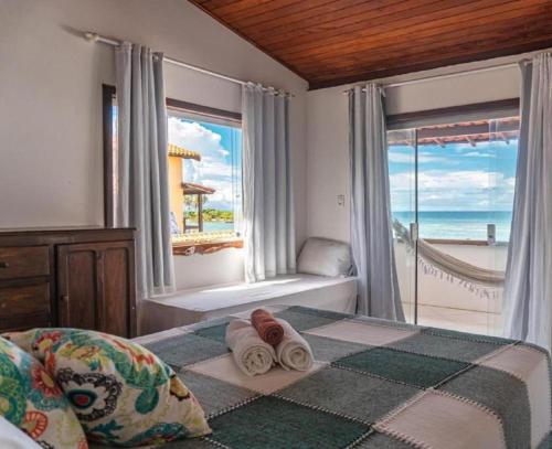 a bedroom with a bed and a view of the ocean at Pousada Gute Morro in Morro de São Paulo