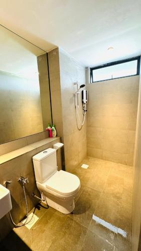 a bathroom with a toilet and a shower at SS Staycation 2 Roxy Sematan Beach Apt in Sematan