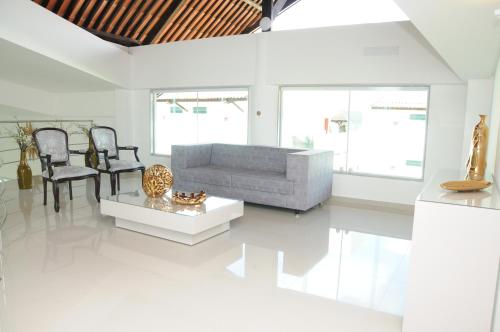 a white living room with a couch and chairs at Reserve Hotel in Surubim