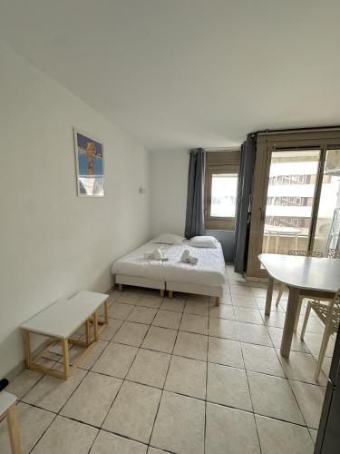 une chambre avec un lit et une table dedans dans l'établissement Résidence Graziella studio 506, à Juan-les-Pins