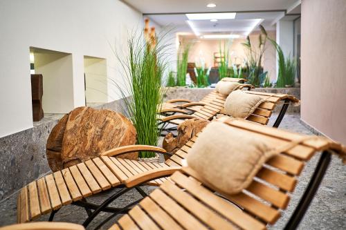 a row of wooden benches sitting in a lobby at Hotel City Krone in Friedrichshafen