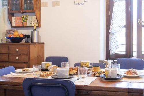 a table with plates of food on it with blue chairs at Italian Experience-Il Borgo Apartment in Bientina