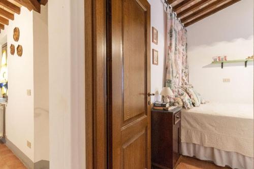 a bedroom with a bed and a wooden door at Italian Experience-Il Borgo Apartment in Bientina