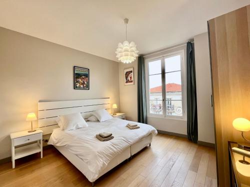 une chambre avec un grand lit blanc et une fenêtre dans l'établissement 4 chambres. Nice French Riviera, à Nice