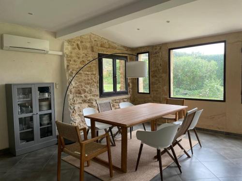 une salle à manger avec une table et des chaises en bois dans l'établissement Bergerie de charme proche Aix en Provence et Lubéron, à Rognes