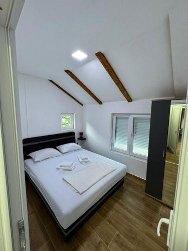 a bedroom with a large bed with white sheets at Villagio in Virpazar