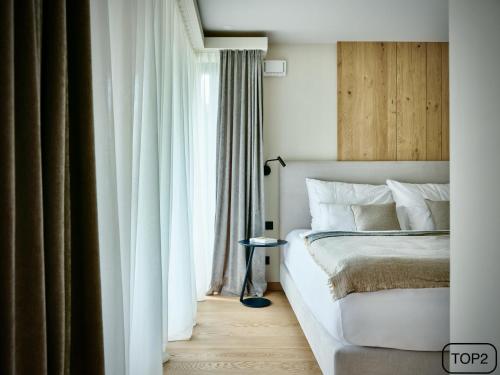 a bedroom with a white bed and a window at Haus am Lift - TOP2 - Summercard included - Ski-in Ski-out - 6P in Zell am See